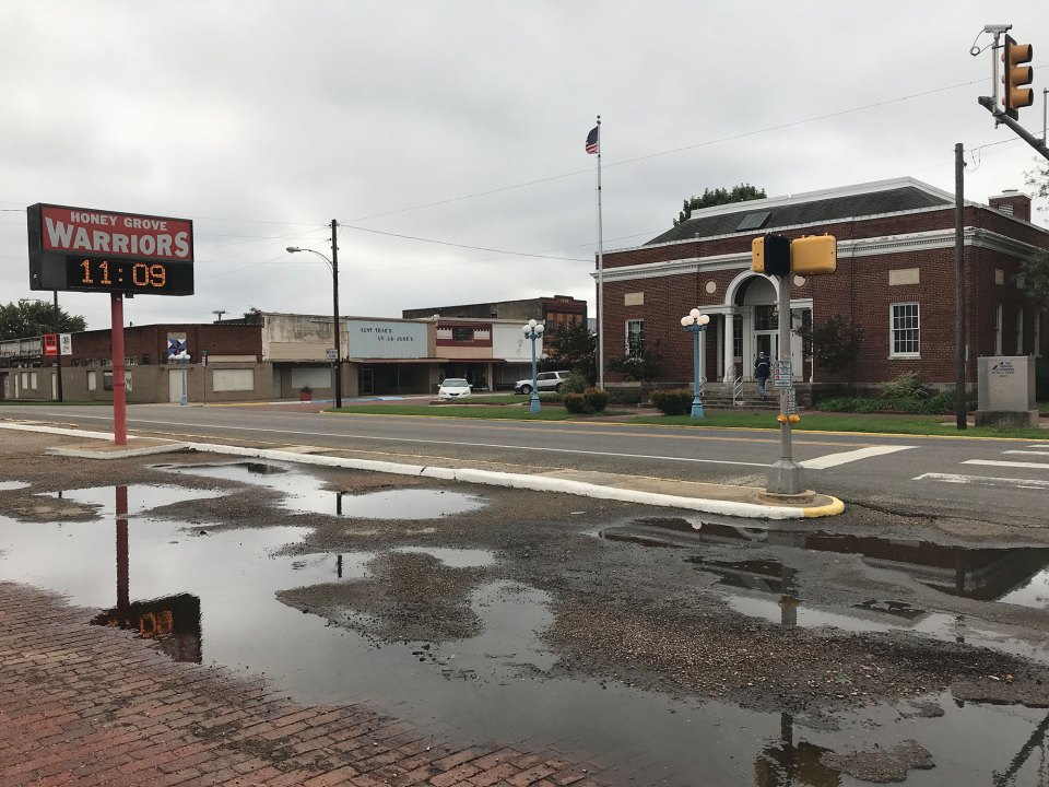 A post office sits opposite a sign for the high school football team on Main Street in downtown Honey Grove.