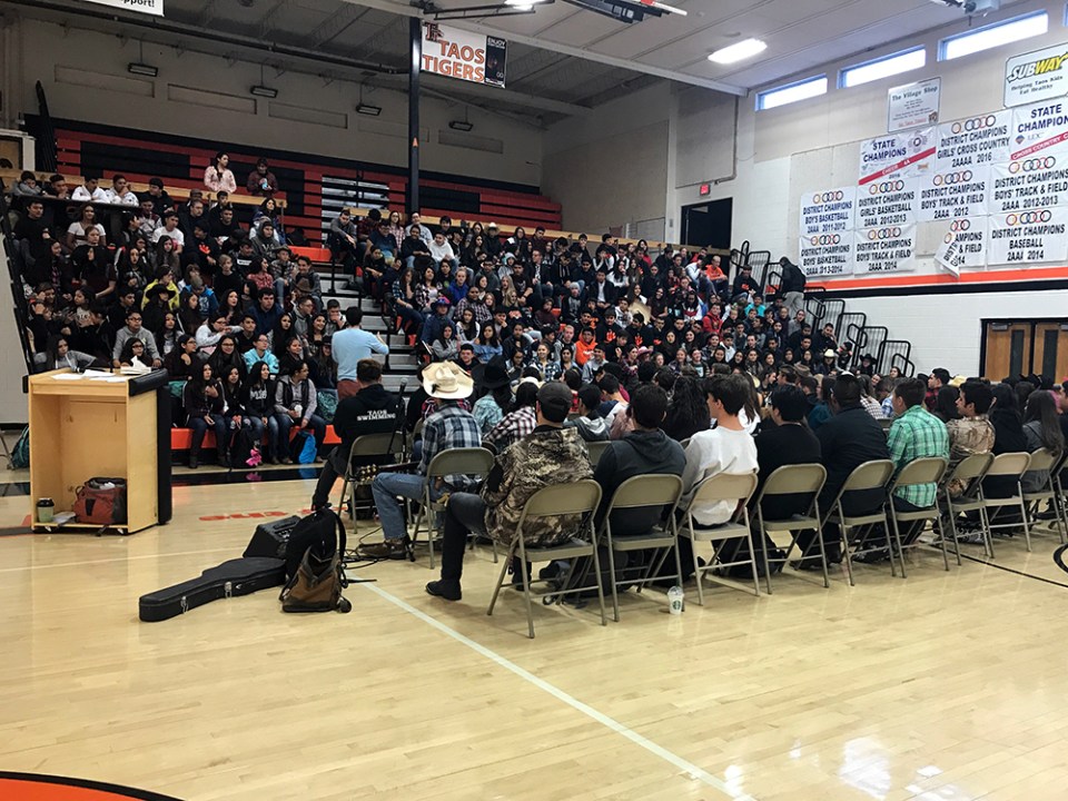 This year’s adult retreat leader, history teacher Ned Dougherty, addresses the whole freshman class (sitting in bleachers) and the 80 seniors who participated in the annual three-day retreat at Taos High in October 2018.