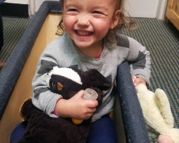 Marin Felman, 2, smiles as she sits in a toy box at her child care center at the Bank Street College of Education in New York City.