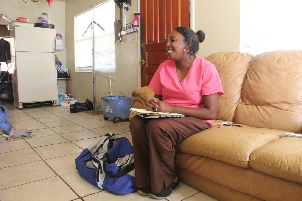 Nurse Polita Williams sits in Tiara Jones’ living room during a home visit.