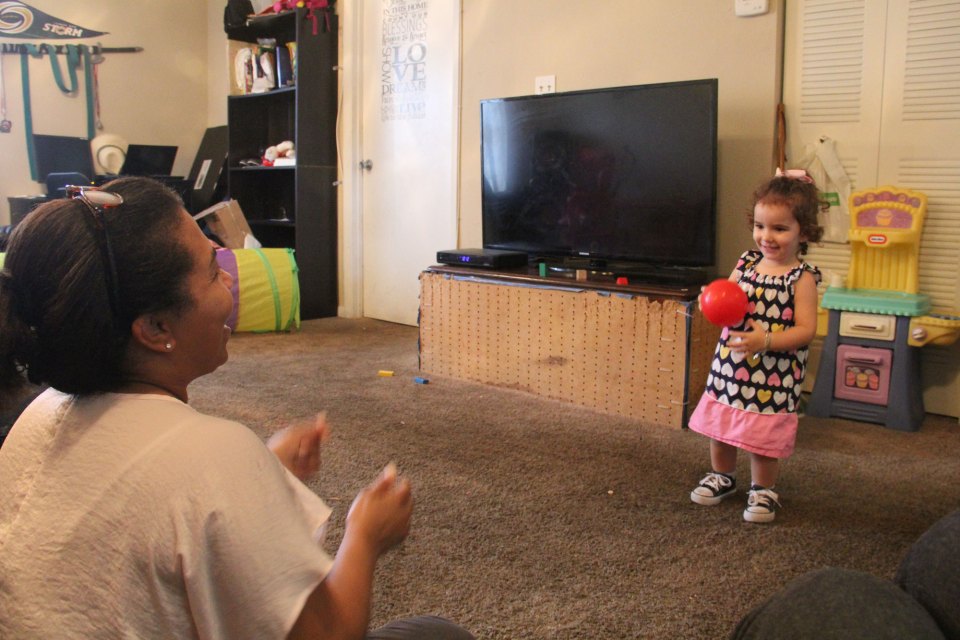 Mercedes Castillo throws a ball to 2-year-old Sonja Morales during a home visit.