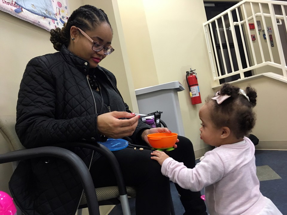 Nikka Norman, a nursing student at the University of Louisville, helps her daughter, Ariyah, with a snack.