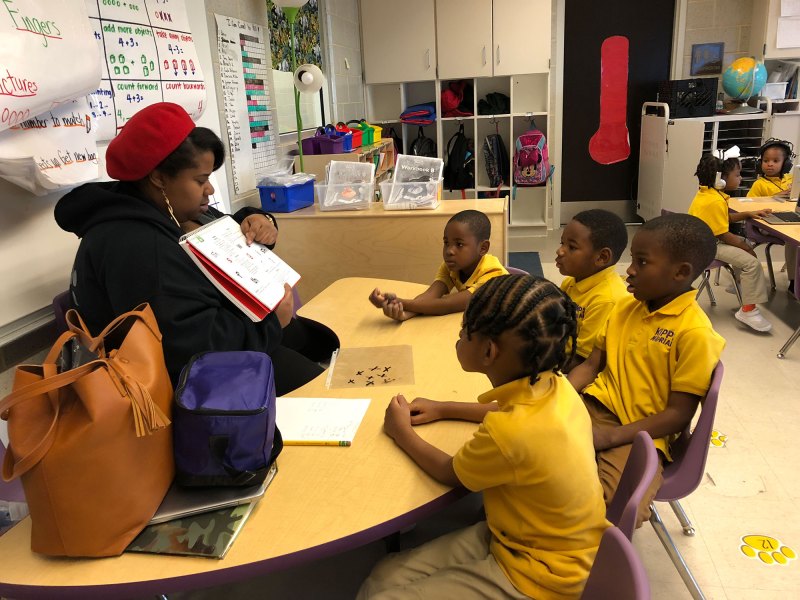 A kindergarten teacher works with a small group of students at KIPP Morial charter school in New Orleans, while other students work on personalized learning software.